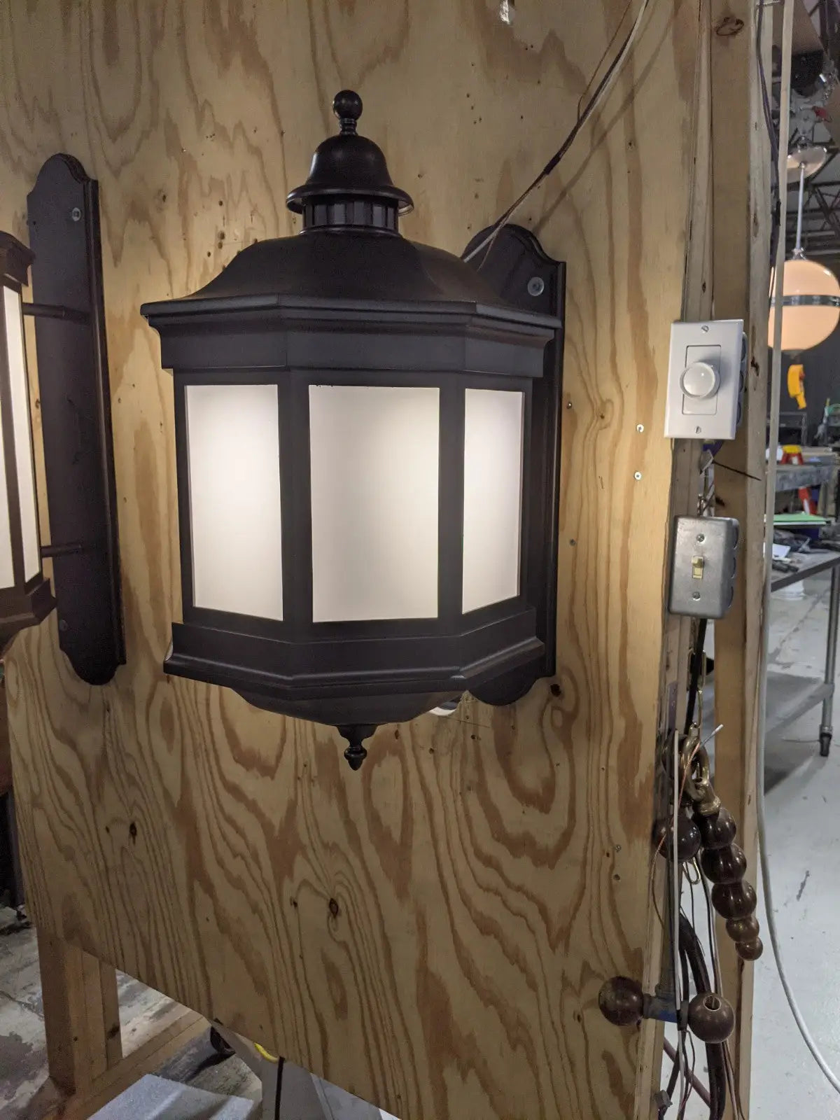A dark bronze outdoor wall lantern with frosted glass panels at Tidwell Bible Building Baylor University