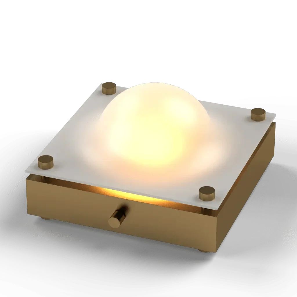 A modern cupola table lamp featuring a square brass and white base with a glowing spherical diffuser