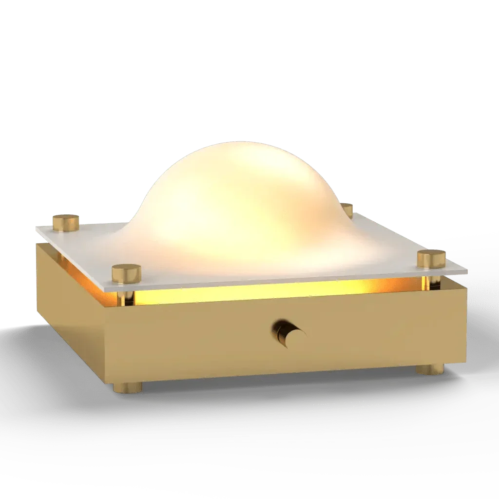A modern gold and white cupola table lamp with a glowing dome-shaped light and sleek tabletop design