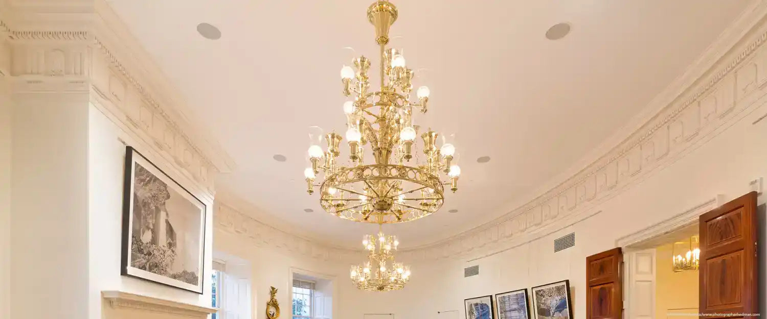 Ornate, multi-tiered brass chandelier with numerous light bulbs.