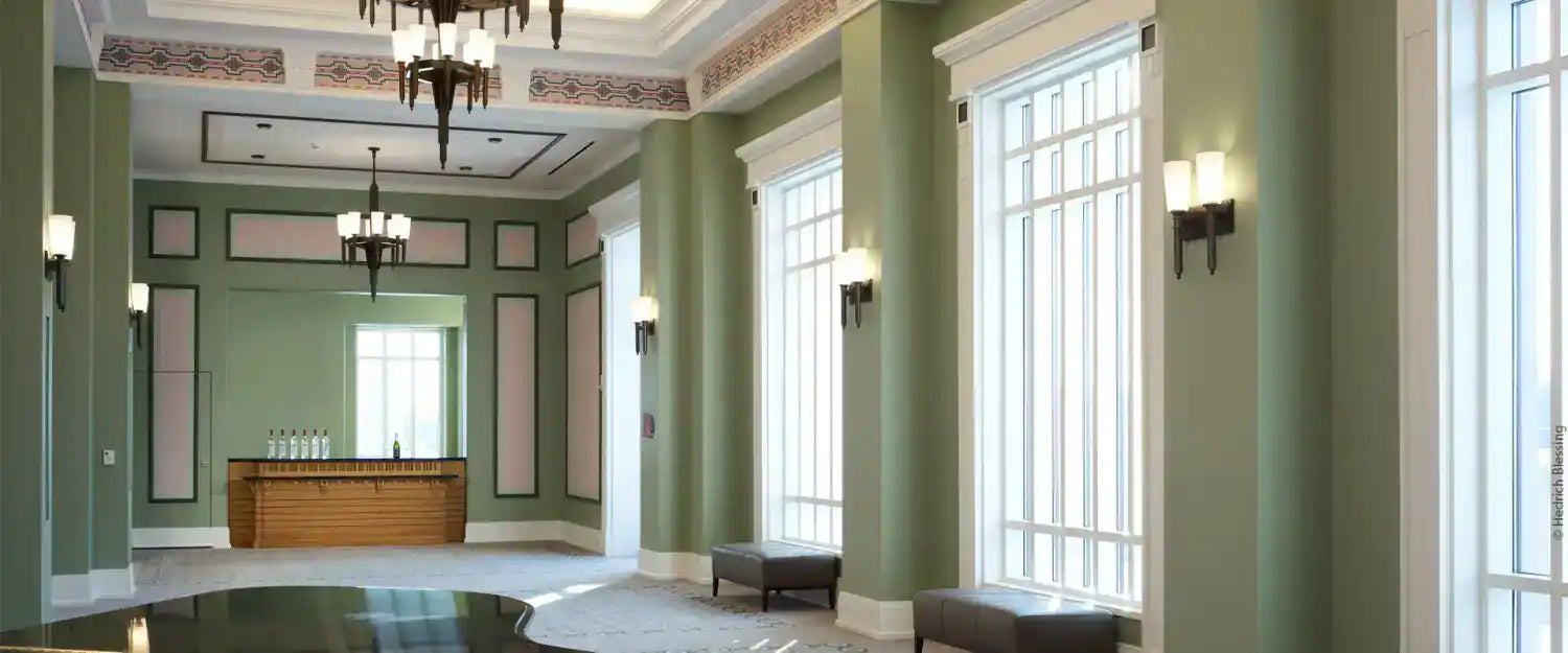 A spacious, elegantly decorated hall with high ceilings and large windows.