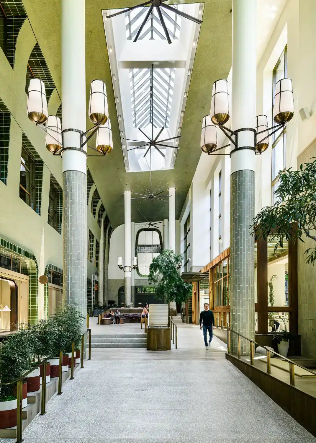 An interior view of a spacious, modern hall with high ceilings, skylights, and decorative lighting fixtures.