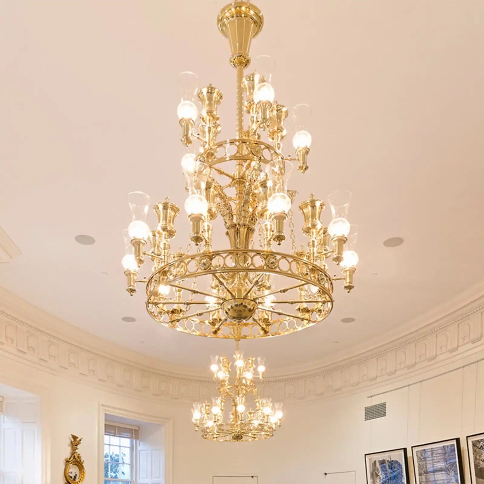 Ornate, multi-tiered brass chandelier with numerous glowing bulbs.