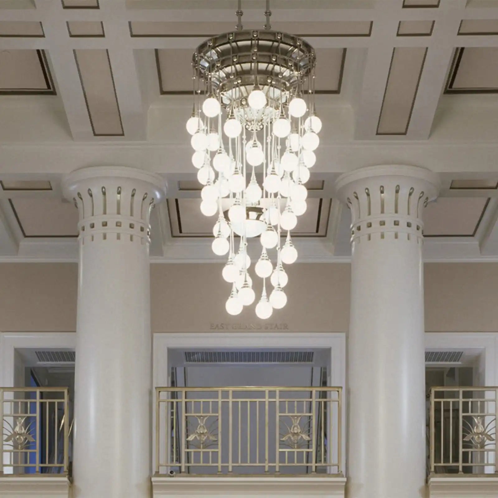 Ornate, multi-tiered chandelier with numerous glowing spherical bulbs.