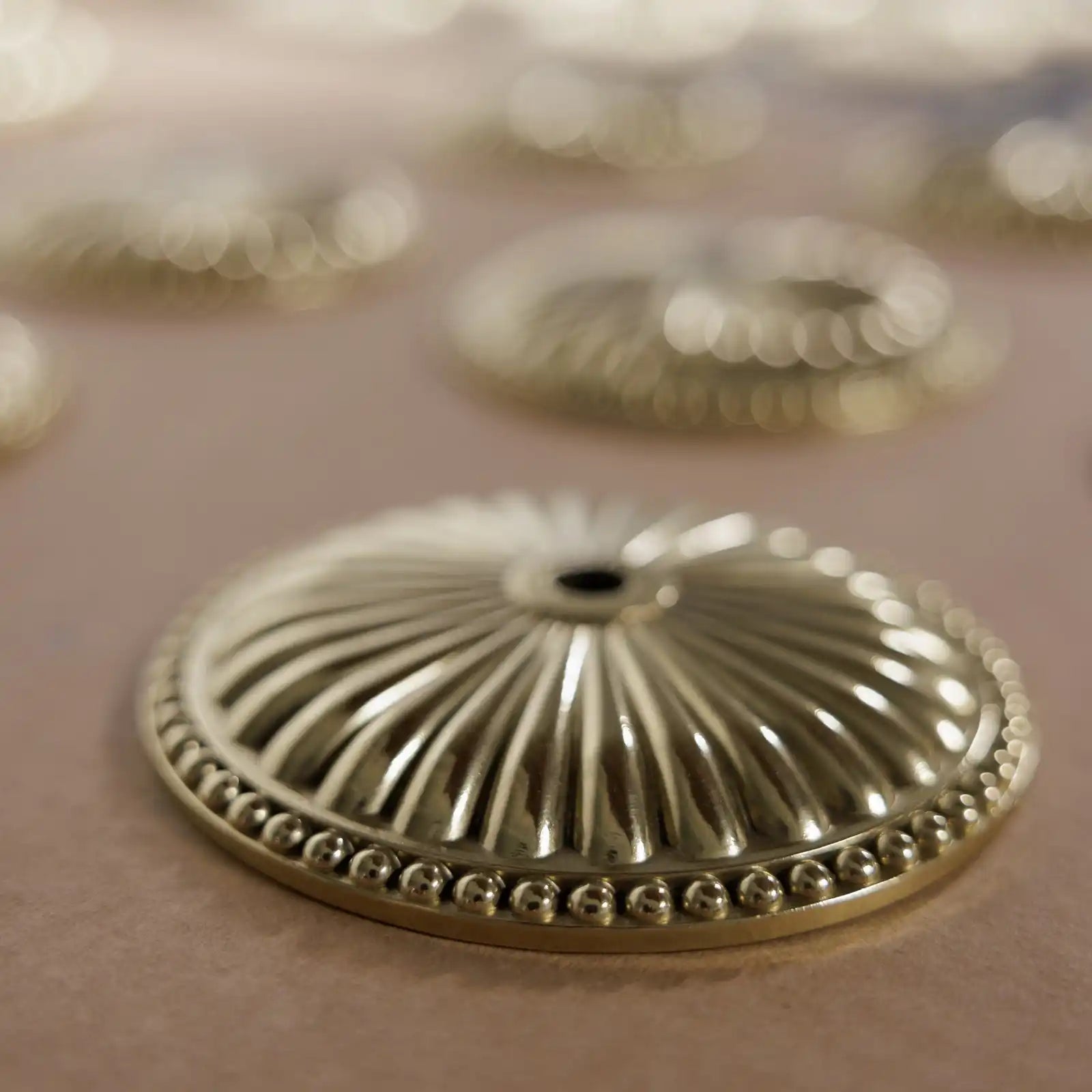 Round, fluted, brass escutcheon with a beaded edge.