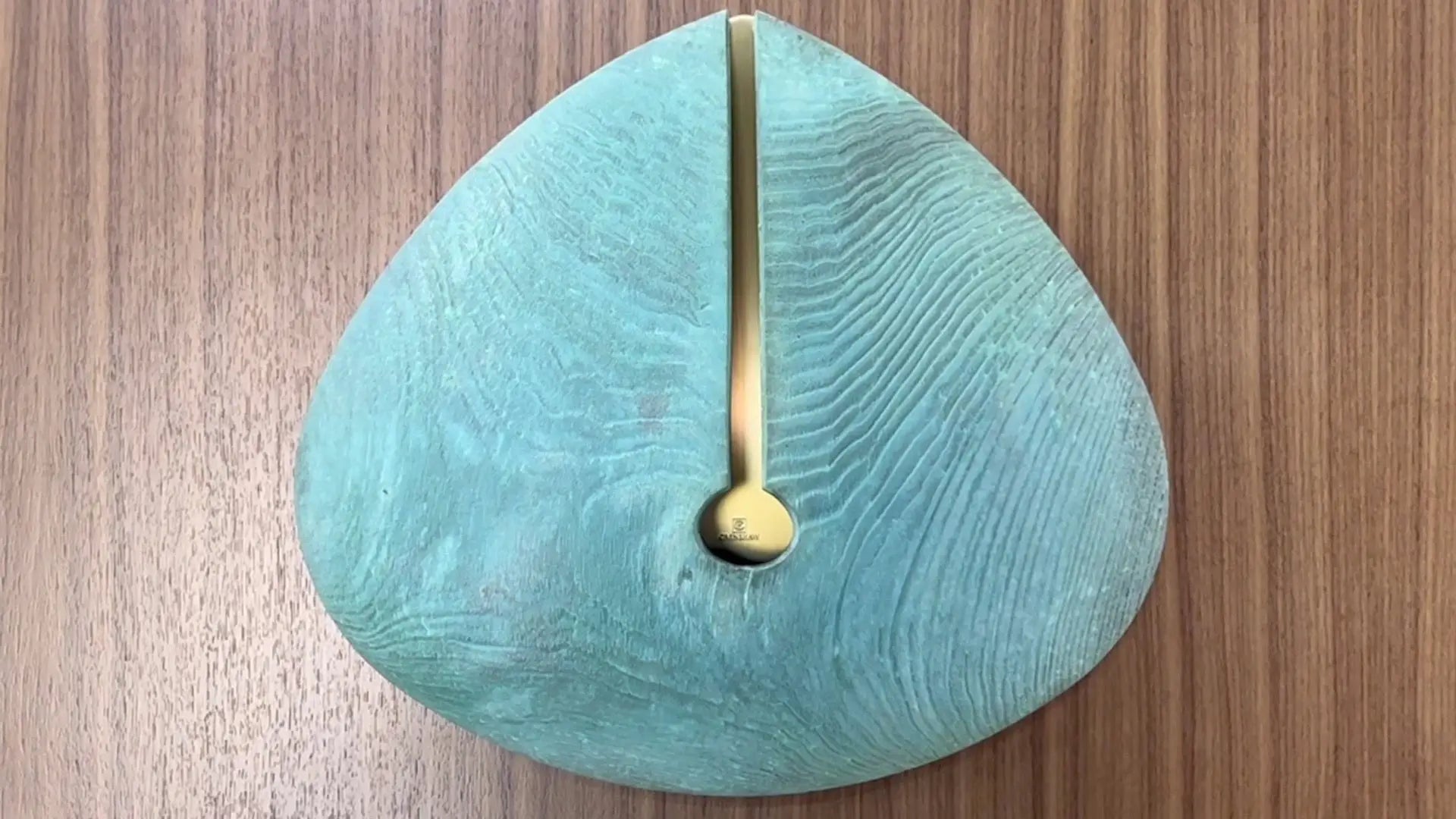 Teardrop-shaped teal wooden decorative object with gold inlay from Crenshaws Lignum Sconce collection