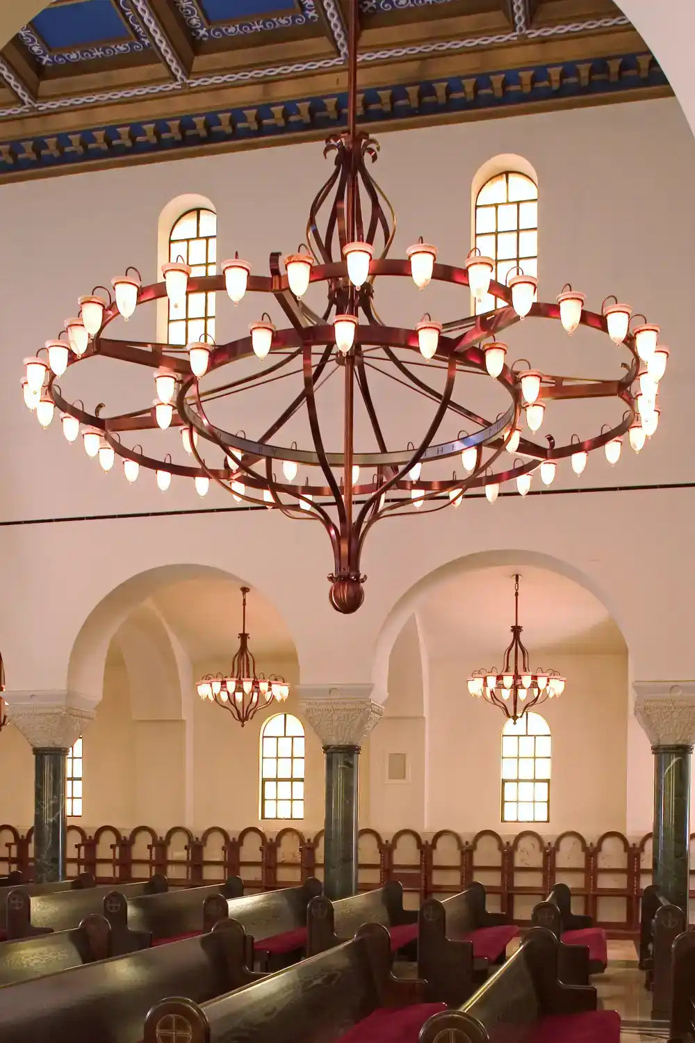 Ornate, multi-tiered chandelier with numerous glowing bulbs.