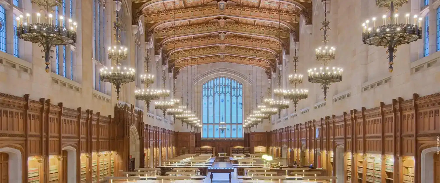 Ornate library reading room with numerous chandeliers and wooden paneling.