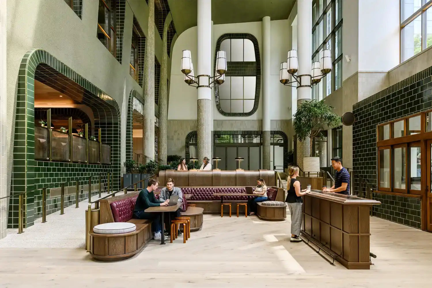 A spacious and modern hotel lobby with a lounge area, bar, and various seating arrangements.