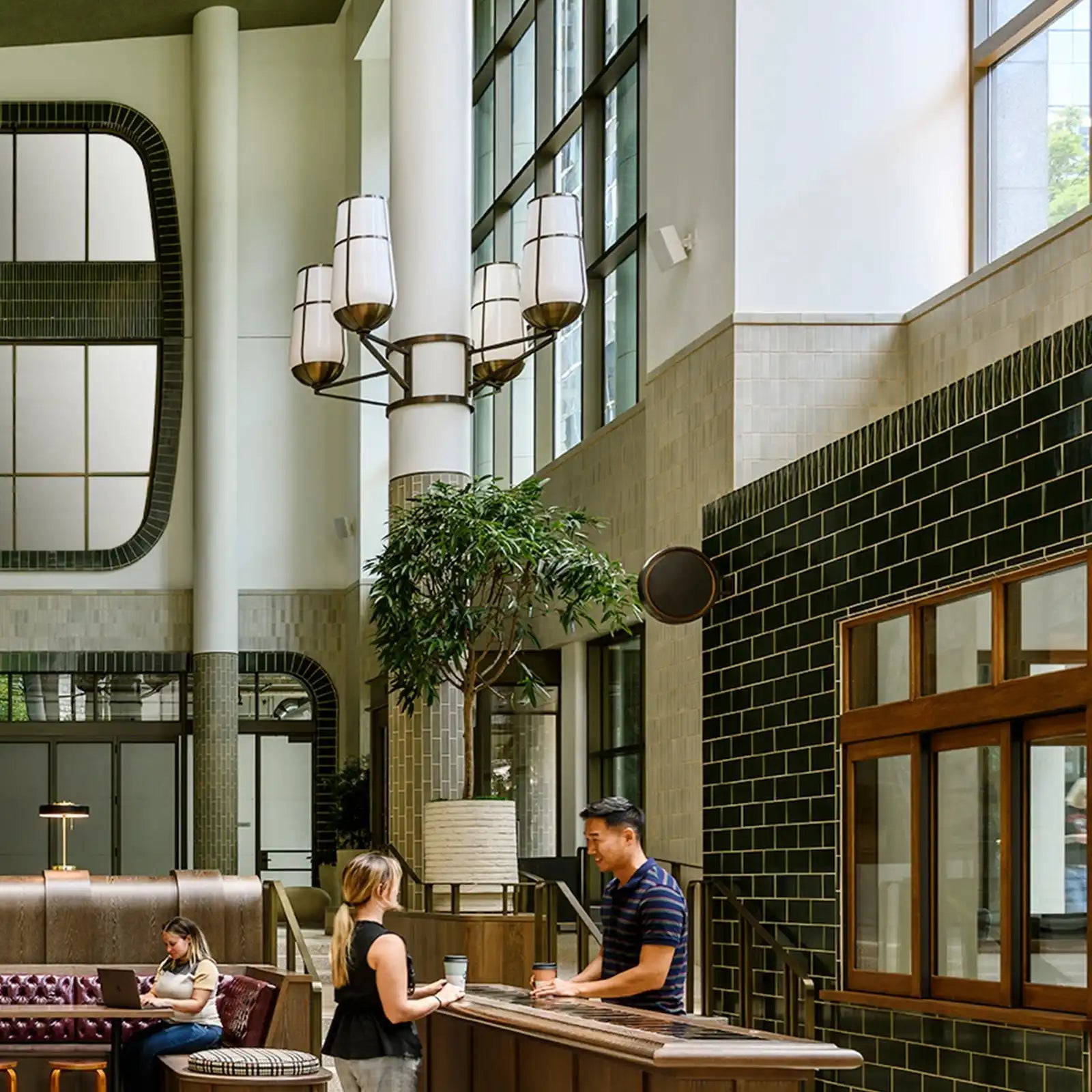 A modern, multi-tiered chandelier with five upward-facing, cylindrical, frosted glass shades and dark metal accents.