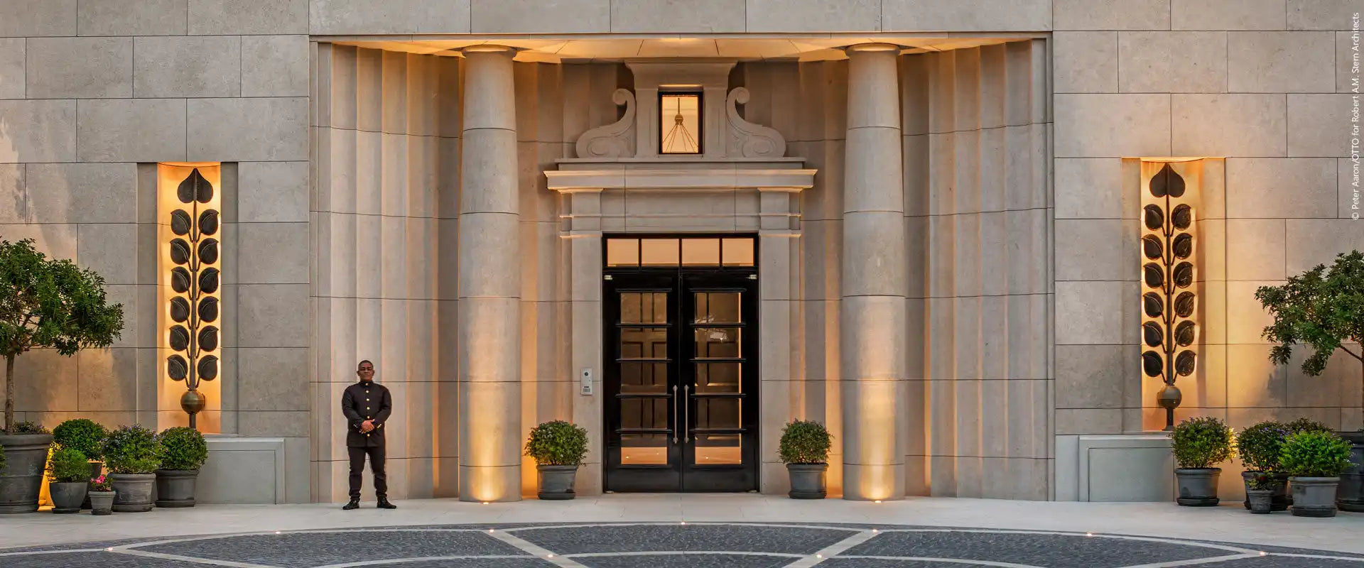 Ornate building entrance with a security guard.