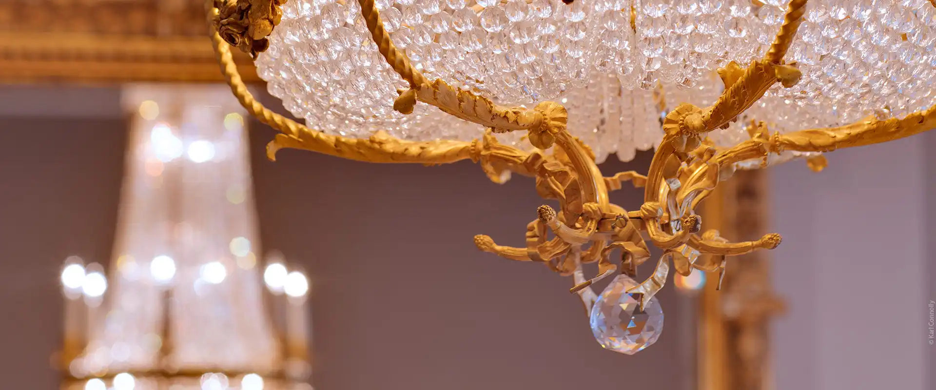 Ornate gold and crystal chandelier with a blurred background.
