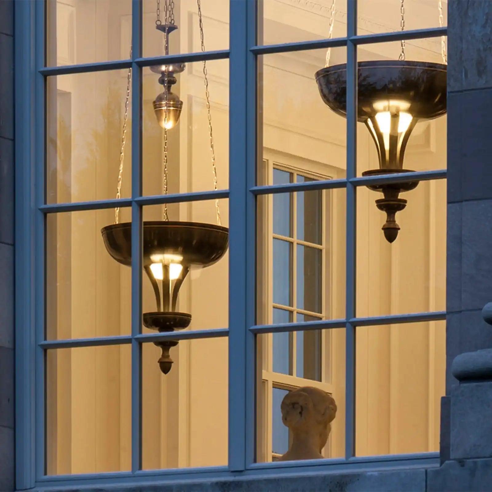 Three ornate hanging lamps with illuminated bases.