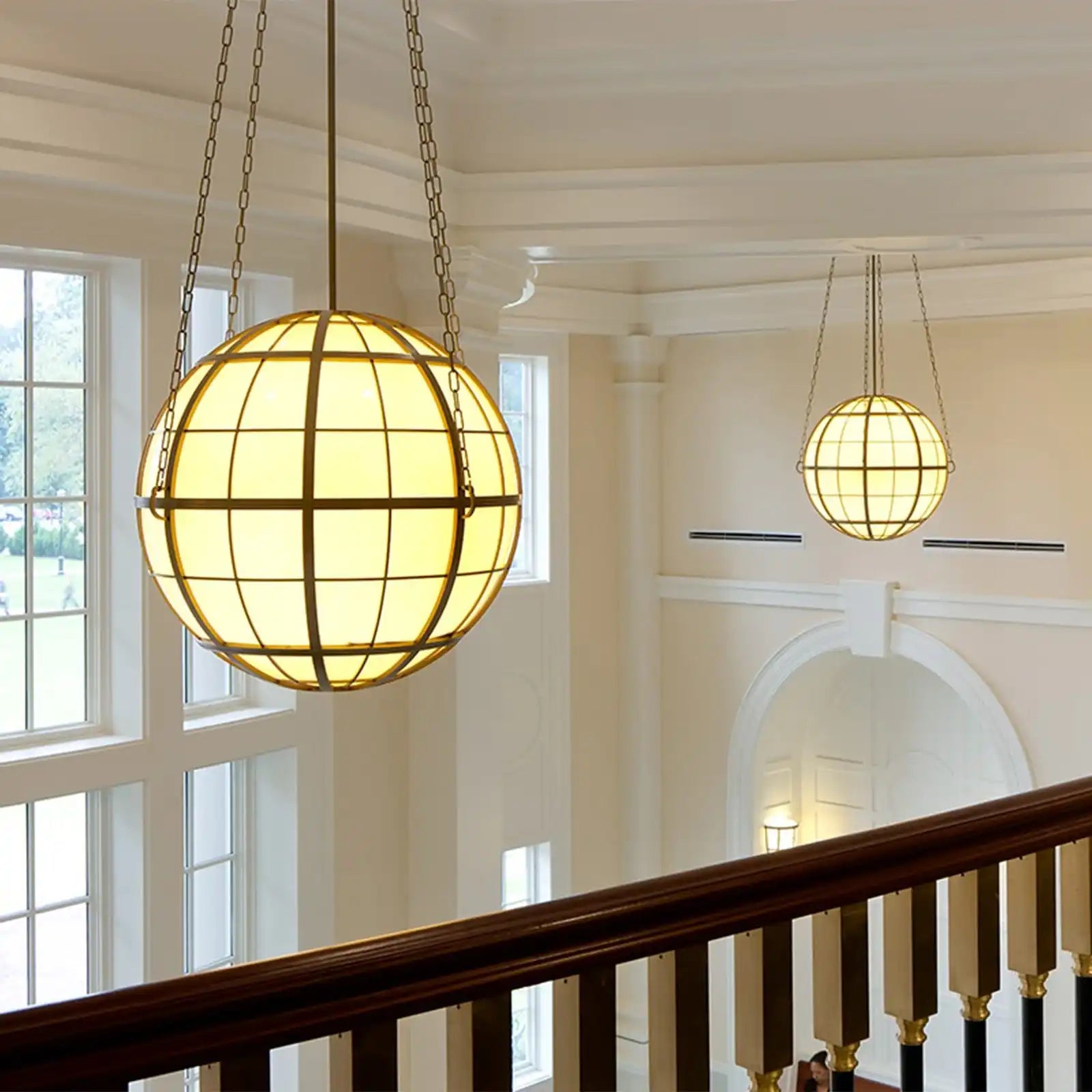 Two spherical, stained-glass pendant lights with metal grilles.
